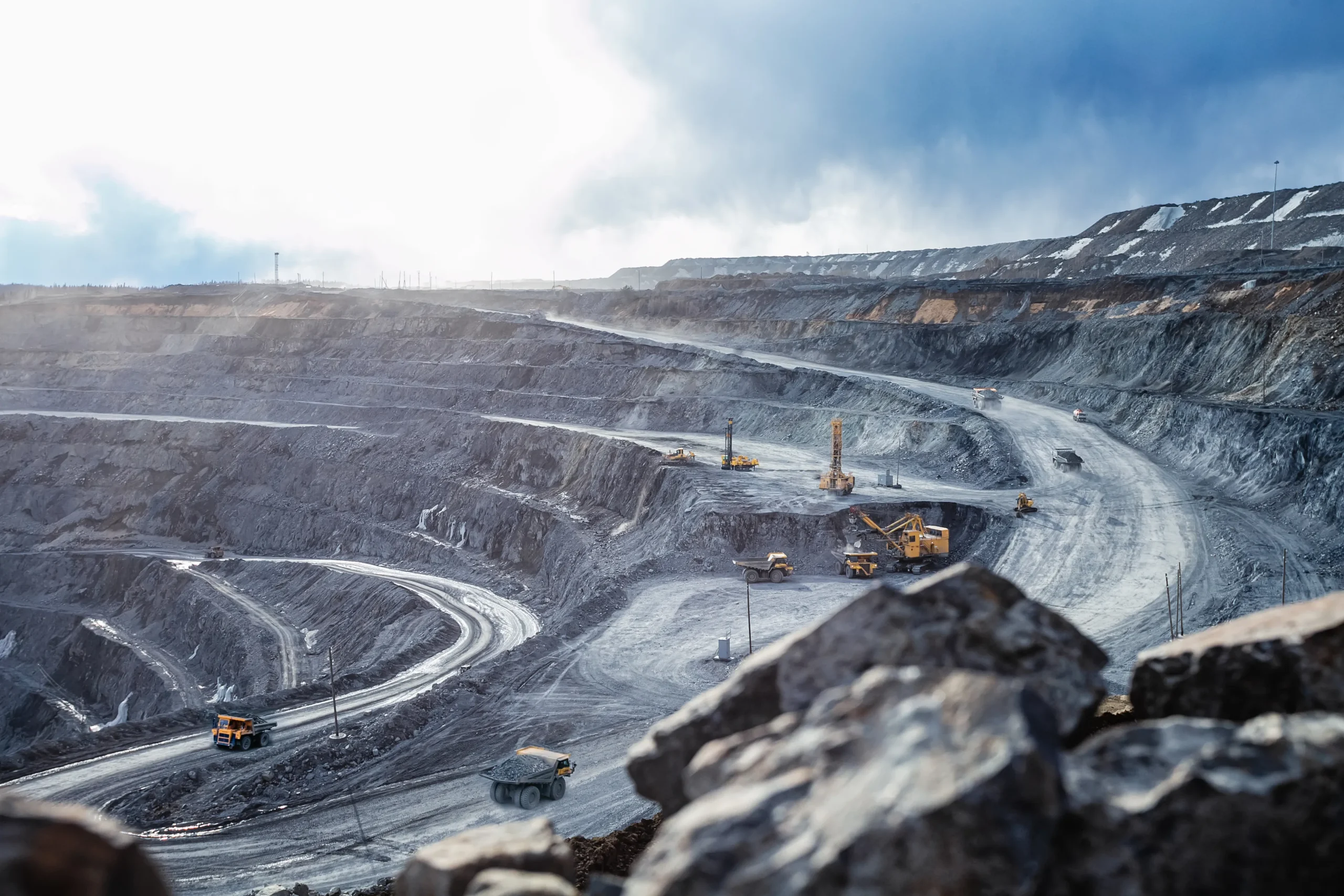 Vue d'une mine à ciel ouvert avec camions et équipements miniers en opération